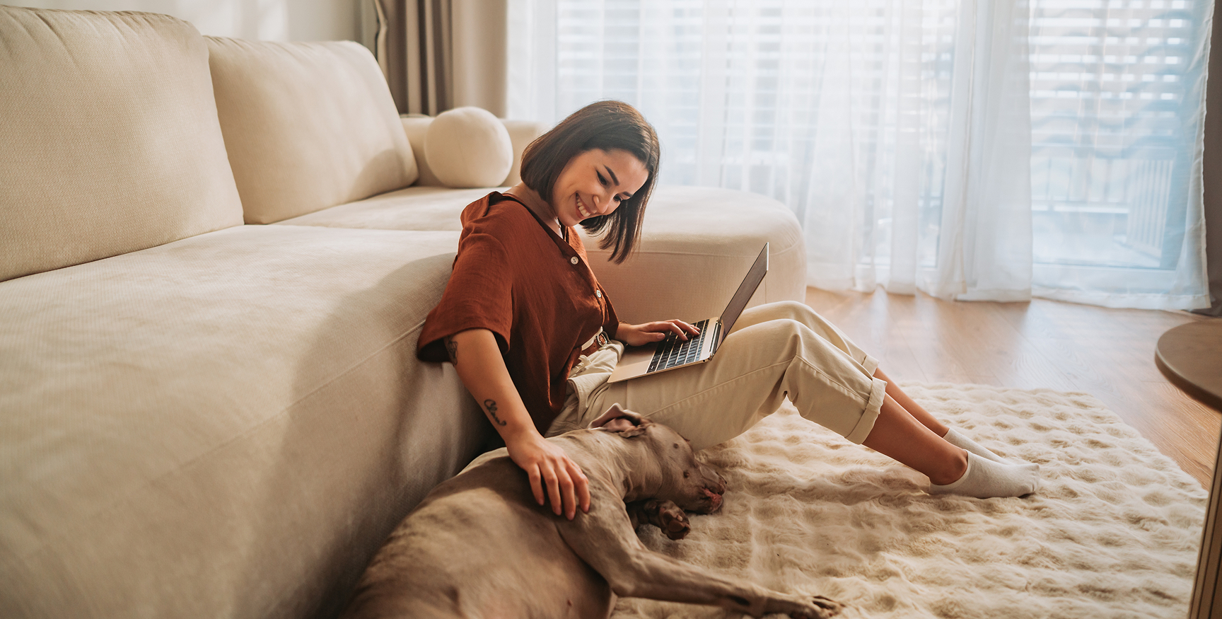 afbeelding van een vrouw die geniet van een aangename dag in haar zetel met haar hond